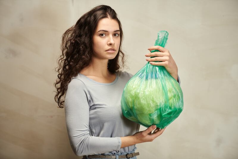 mujer con basura en la mano.